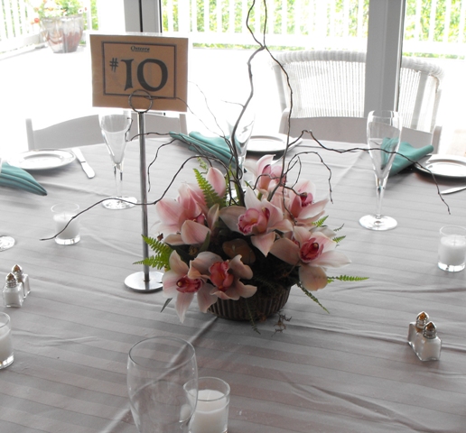 pink cymbidium orchid centerpiece with branches and rocks